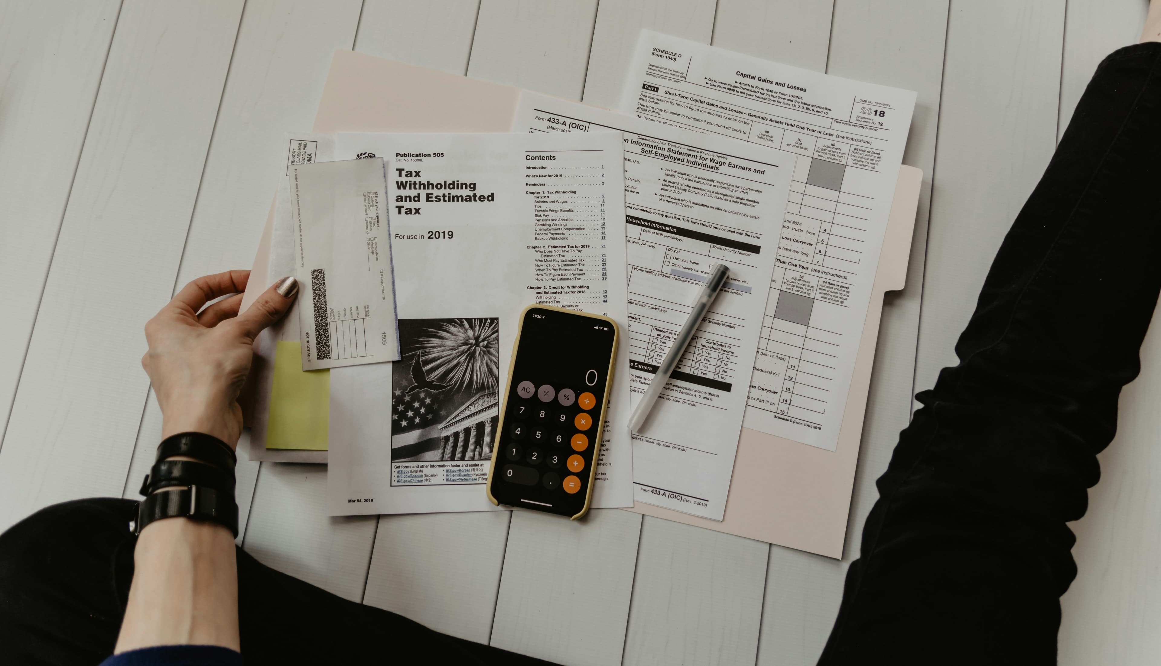 Hands sorting through a pile of financial forms